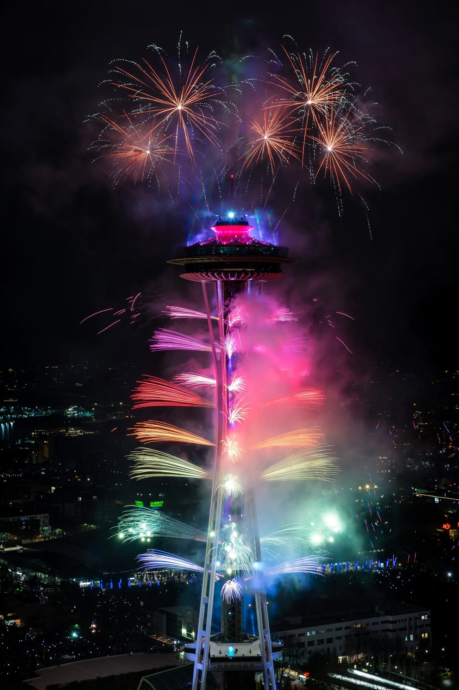 Fireworks illuminating the night sky above the Space Needle during a celebration or event.